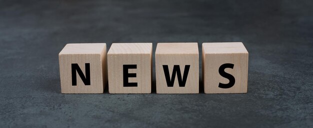 The word news is standing on wooden cubes information and social media concept headline