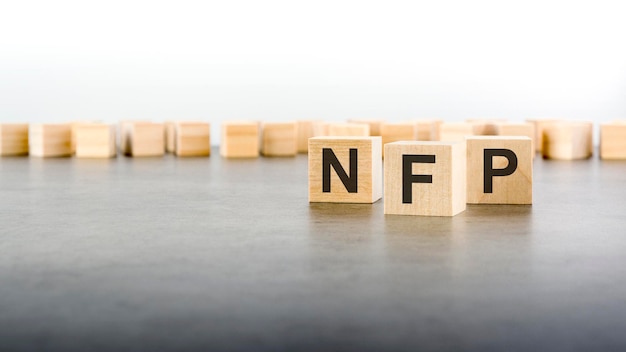 単語 nfp は、灰色の背景に木製のブロックで作られています
