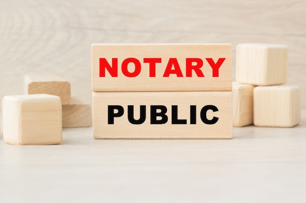 The word notary public is written on a wooden cubes structure