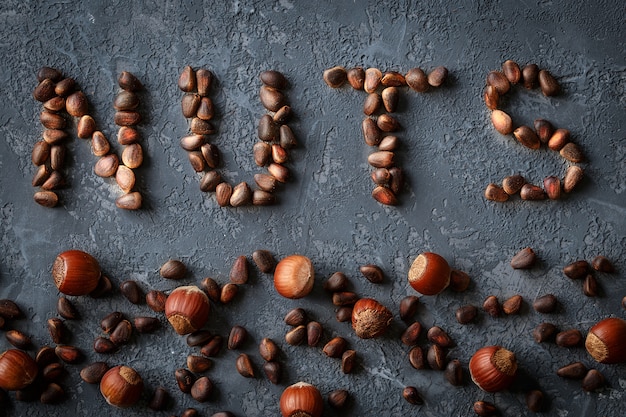 Word "Nuts" made of mixed nuts,  hazelnuts, Pine nuts