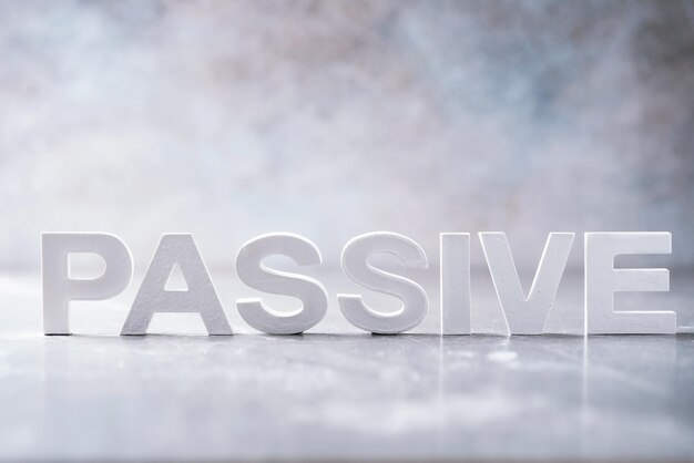 Photo word passive made with cement letters on grey marble background copy space business concept