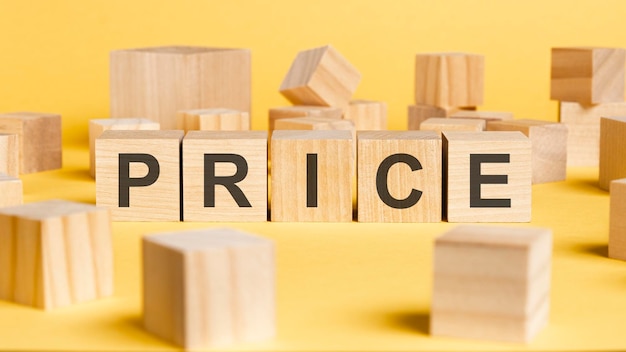 The word price written on wooden cubes on yellow background