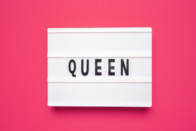 Word QUEEN White lightbox with letters on pink background