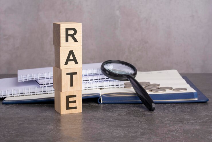 Photo the word rate is written on wooden cubes on a gray background closeup of wooden elements magnifying glass paper documents and coins on a notebook