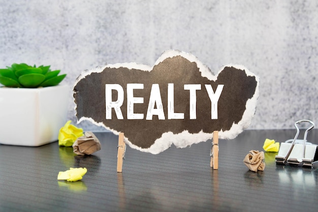 word realty on paper black background copy space Male hand Business concept success process