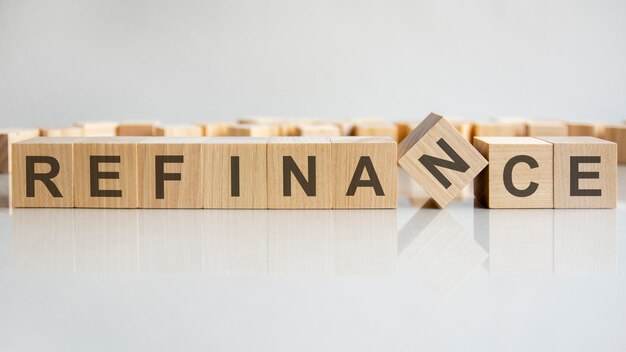 Word refinance on wooden cubes, gray background.