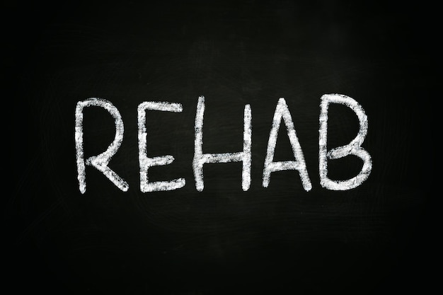 Photo the word rehab written with chalk on blackboard