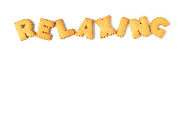 The word RELAXING, made with alphabet shape biscuits on white background