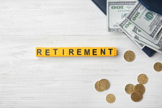 Photo word retirement and money on light background pension planning