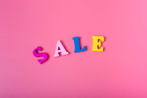 The word sale on a pink background of multicolored letters