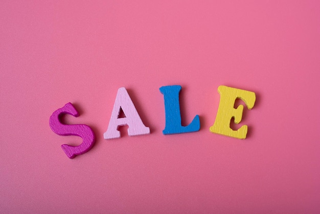 The word sale on a pink background of multicolored letters