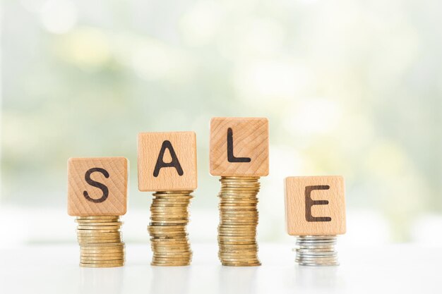 Word sale and stack coins on green background