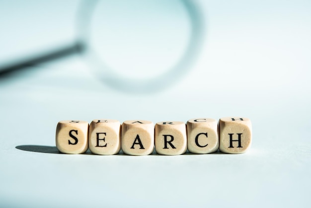 The word search in English and in the background a magnifying glass Search concept research