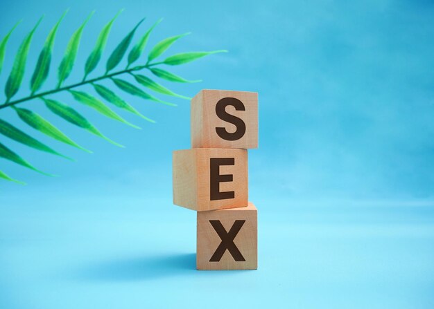 The word sex is set in wooden cubes on the background of many question marks Sexual Health