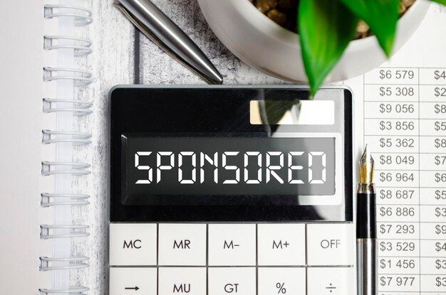 Photo word sponsored on table calculator finance concept