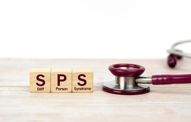 word SPS (Stiff Person Syndrome) on wooden blocks and stethoscope on white background. Medical, heal