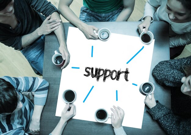 Photo the word support on page with people sitting around table drinking coffee