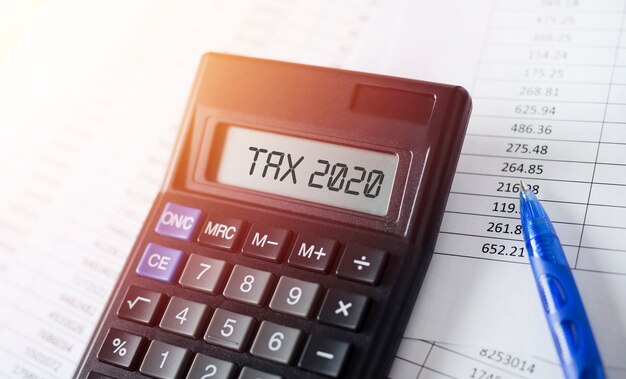 Word Tax 2020 on calculator. Business and tax concept.