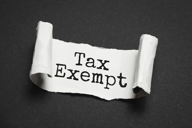 The word tax exempt appearing behind torn paper