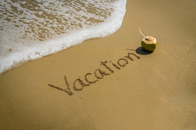 Word vacation on the beach sand - vacation and travel