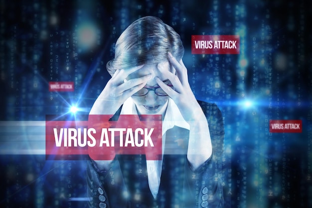 Foto la parola attacco di virus e donna d'affari rossa con la testa tra le mani contro linee di lettere sfocate blu che cadono