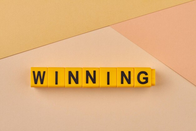 Word winning written on plastic blocks against color background minimal composition