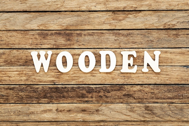 Photo the word wooden written on wood letters on wooden background top view