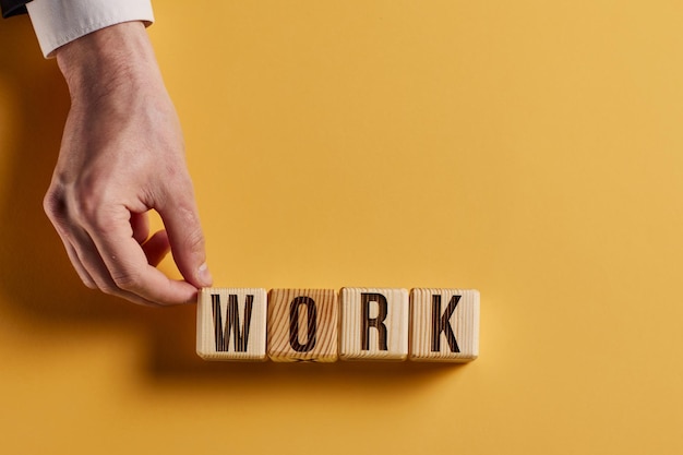 Photo the word work is written in wooden cubes in black letters on a yellow background