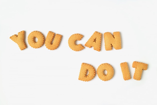 Photo the word you can do it spelled with alphabet shaped biscuits isolated on white background