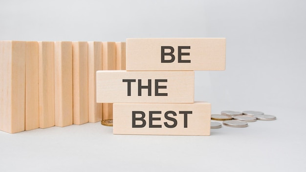 The words Be The Best are written on a wooden cubes structure. Cube on a gray background. Selective focus. copy space