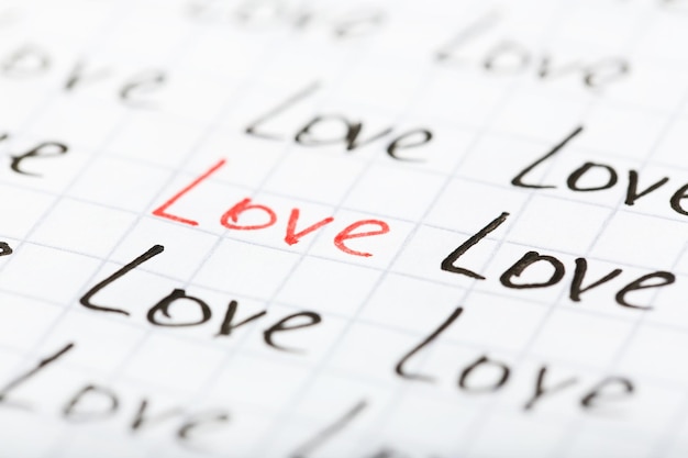 Words LOVE written on sheet of paper background