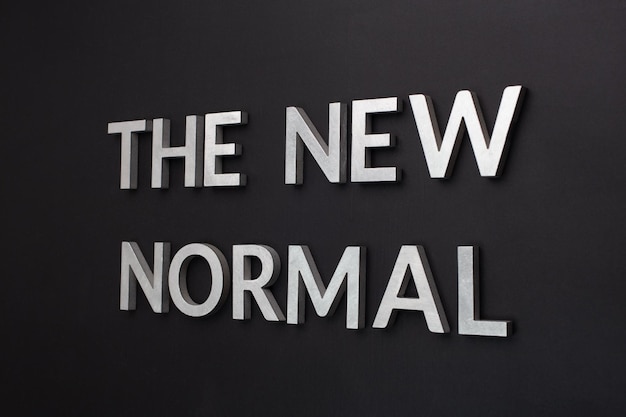 Words the new normal on black surface in tilted linear perspective