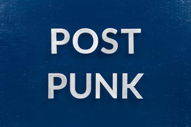 Words post punk laid with aluminium letters over blue painted board surface full frame concept