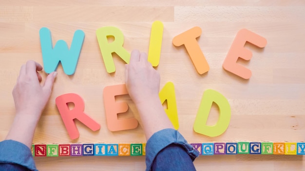 Photo words read and write from multicolor wooden letters on wooden table.