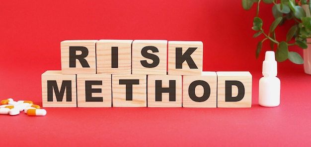 The words RISK METHOD is made of wooden cubes on a red