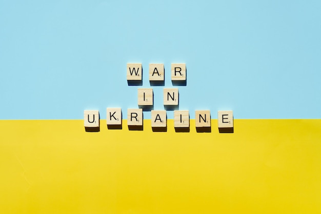 Words on wooden alphabet letters on yellow, blue background. Flat lay. Concept of freedom. Ukraine