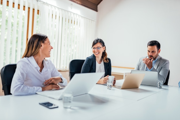 Work colleagues chatting in board room.