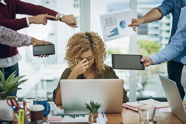 Photo work commitments are closing in on her. shot of a young businesswoman looking stressed out in a demanding office environment.