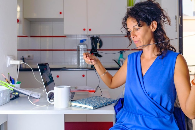 Foto giornata lavorativa in ufficio a casa. la ragazza lavora dietro il computer portatile a casa con le cuffie e la tazza di caffè.