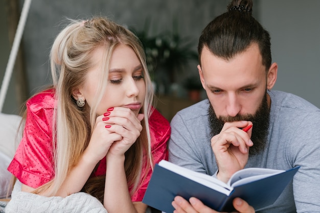 Pianificazione della giornata lavorativa. uomo e donna a letto a prendere appunti.