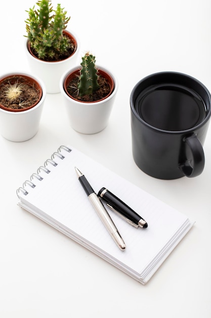 Photo work desk with coffee tiny cactus and notepad