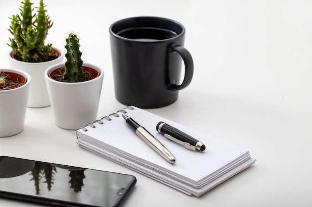 Work desk With smartphone Coffee tiny cactus and notepad