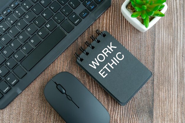 Work ethic text on note pad on top of desk flat lay