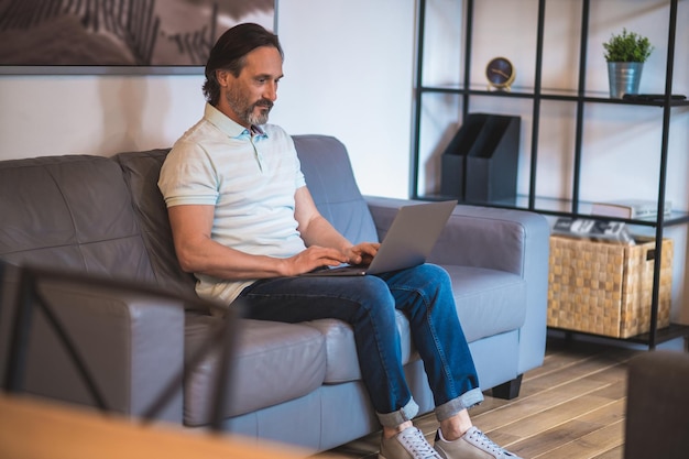 Work from home. mature dark-haired man working remotely from\
home