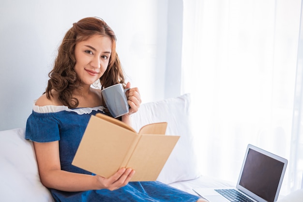 Foto lavora da casa, giovane donna asiatica che lavora al computer portatile mentre era seduto in salotto