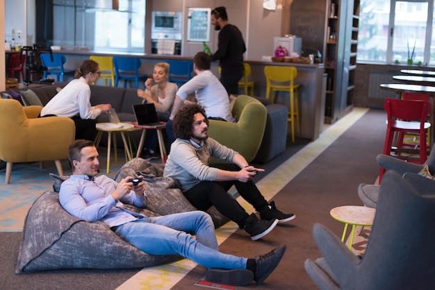 Work hard play hard. Workers Playing computer games in creative startup Office