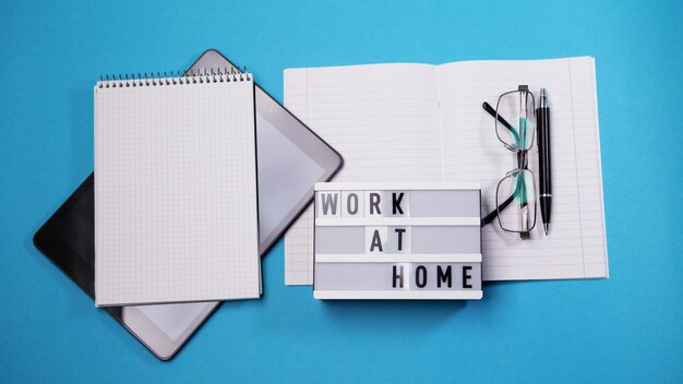 Work at home inscription with tablet pc on blue background