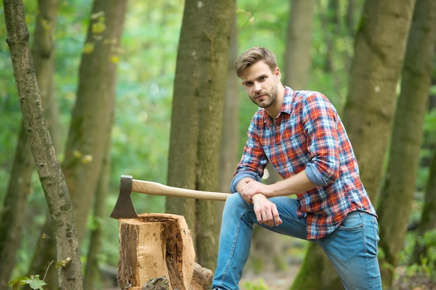 Work is done camping and hiking outdoor activity strong man with ax woodcutter ranch man carry axe sexy guy wear shirt in forest male power and energy firewood at the campsite