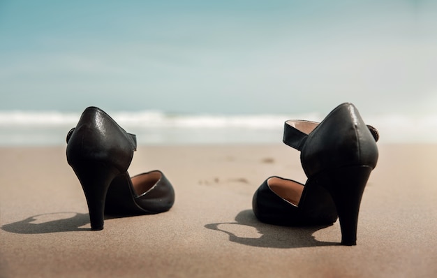 Work life balance concept. business woman take off working\
shoes on the sand beach, walk to the sea