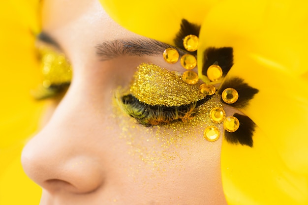 The work of the make-up artist. Beauty portrait of a brunette with long eyelashes in the form of a tulip. Eye close up